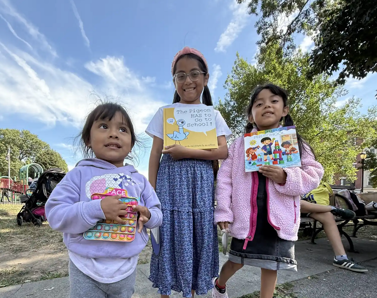 Tres hermanas reciben con entusiasmo libros nuevos al final de un evento de lectura. Gracias a LINC, muchas familias pueden comenzar a formar su propia biblioteca en casa, sin costo alguno. Créditos: Anny Ruiz Huayamabe